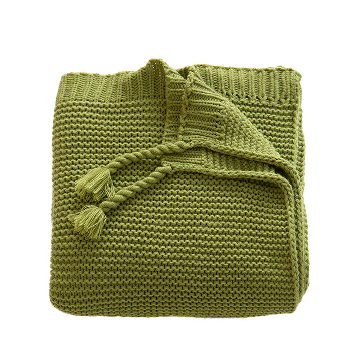 Chunky knitted cozy blanket with diamond pattern and colorful knots