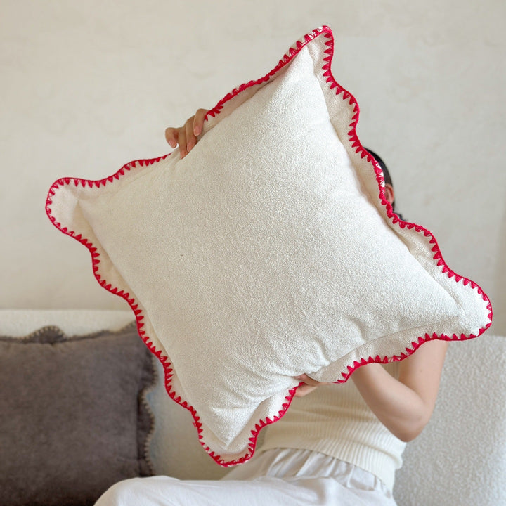 Decorative velvet cushion with wavy edge and decorative stitching