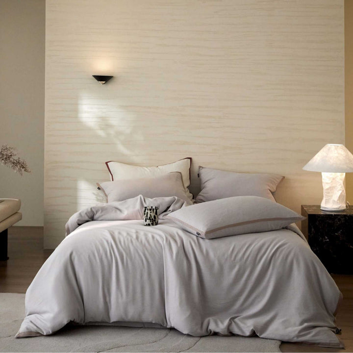 Stonewashed cotton bed linen set with contrasting piping and soft touch