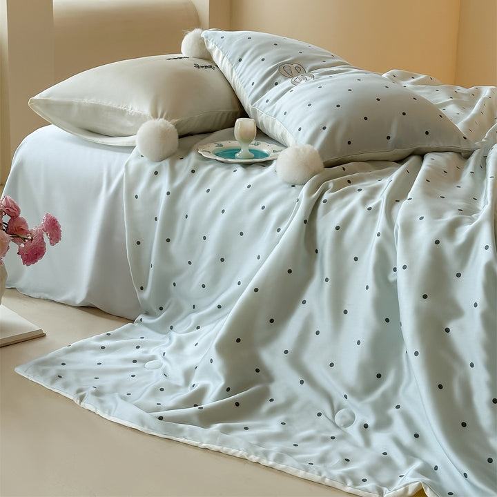 Luxurious satin bedding set with polka dot pattern and pom-pom tassels