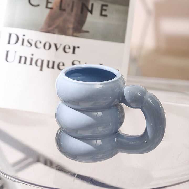 Sculptural ceramic mug with iridescent glaze and curved ring handle