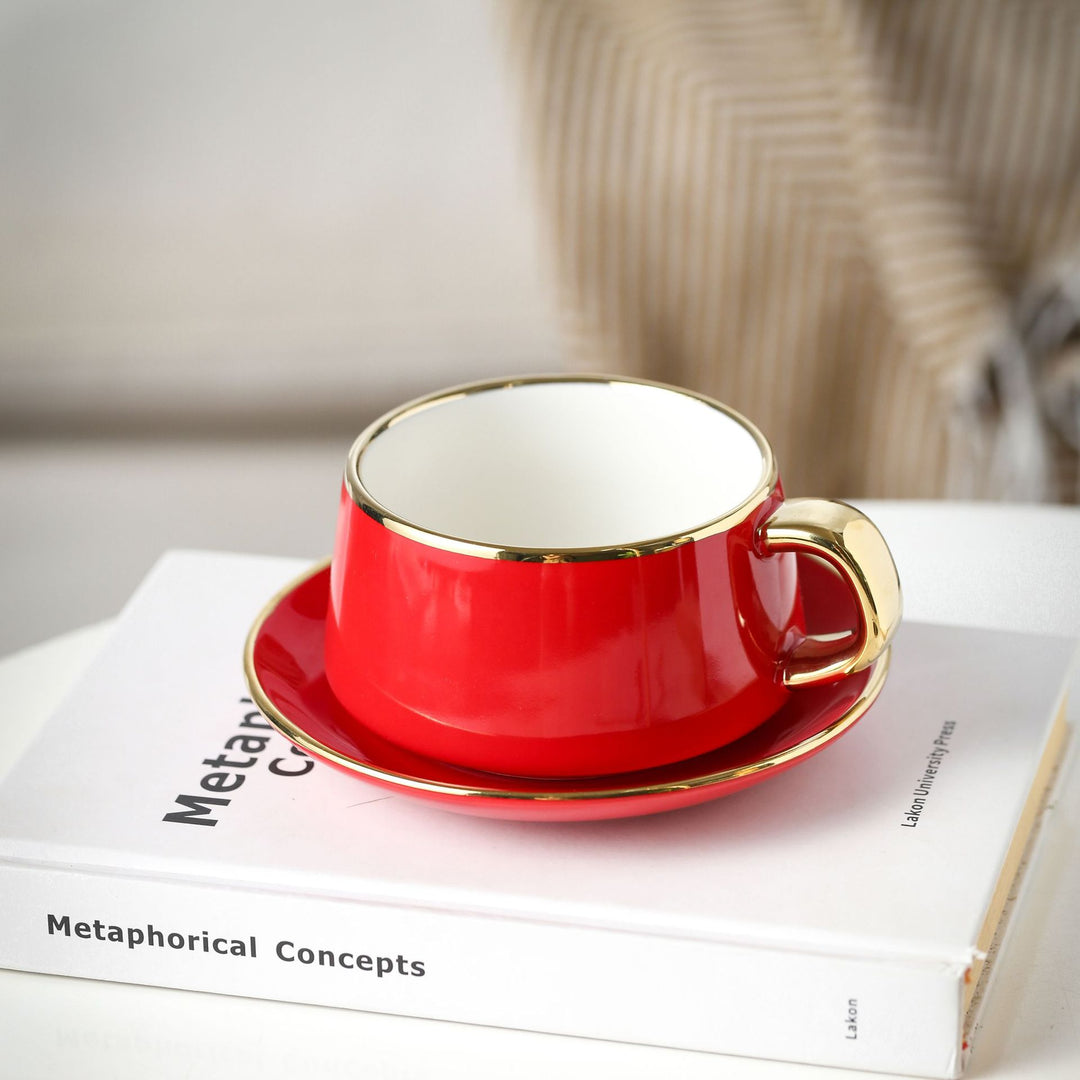 Elegant porcelain cup with saucer and sculptural gold handle