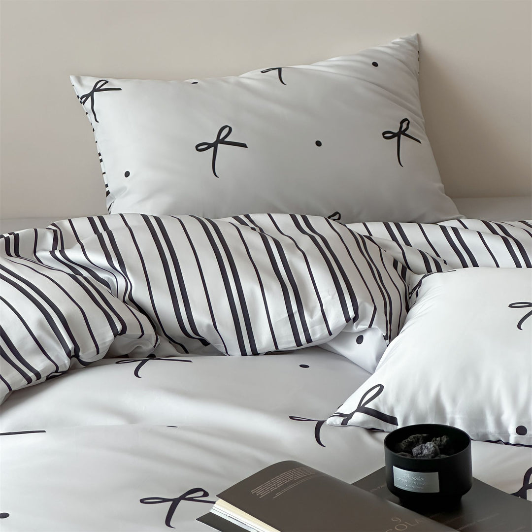 Modern cotton bedding set with minimal bow print and striped reversible side