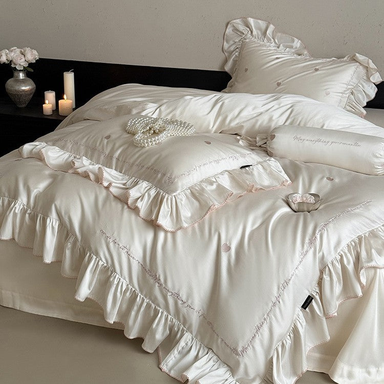Luxurious cotton satin bedding set with ruffled trim, embroidered heart motifs, and calligraphic writing