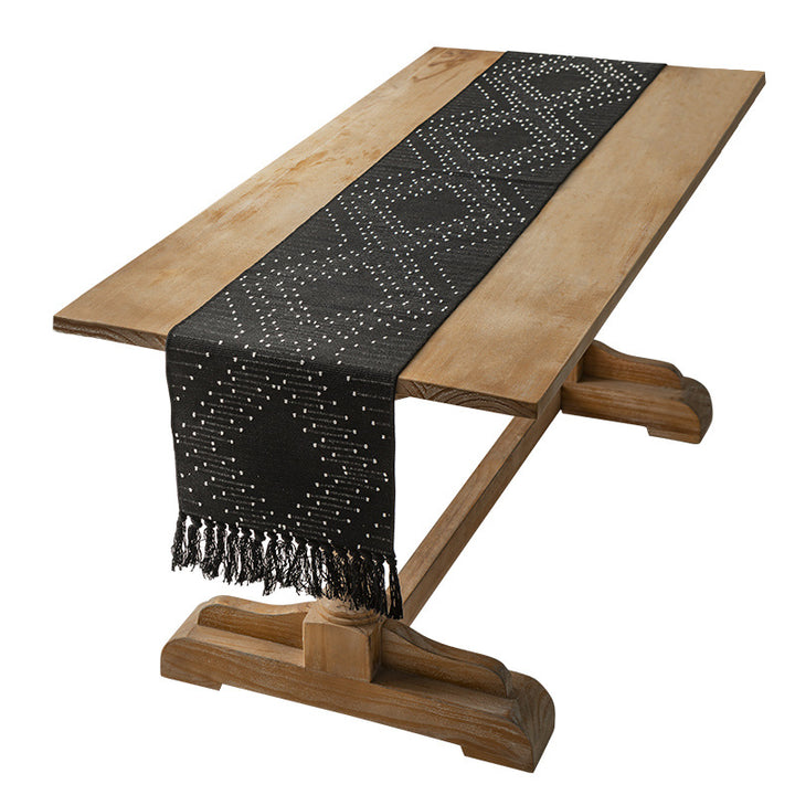 Woven table runner with geometric polka dot pattern, hand-fringed edge and sturdy cotton blend