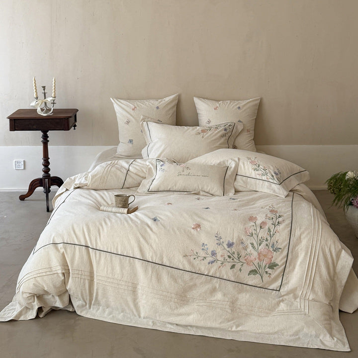 Natural fiber duvet cover set with delicate floral hand embroidery, linen look, and decorative ruffle