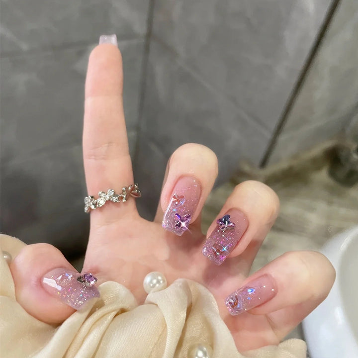 Glamorous artificial nails with glitter and floral accents Kalsten