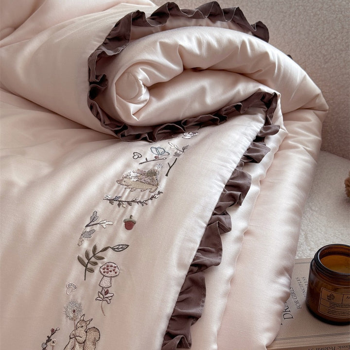 Quilted reversible duvet cover with floral embroidery and ruffled hem