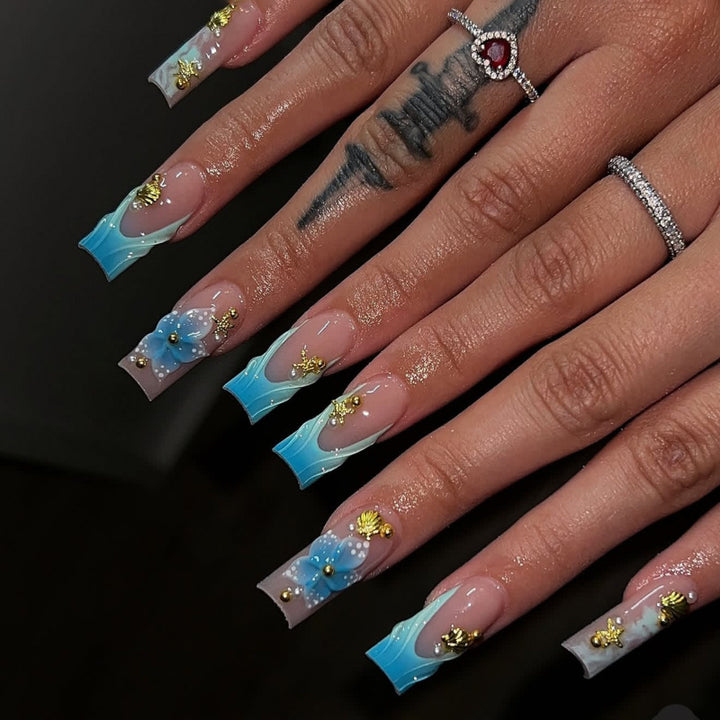 Artful nail art with floral accents and glitter effects Kalsten