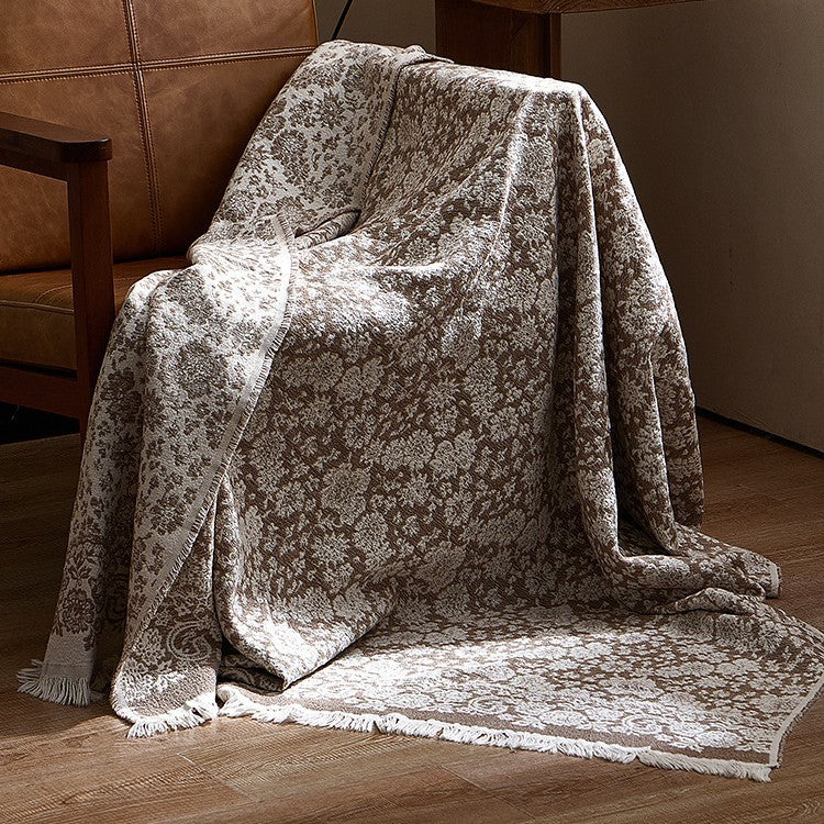 Large cozy living blanket made of cotton blend fabric with geometric jacquard pattern and fringed hem