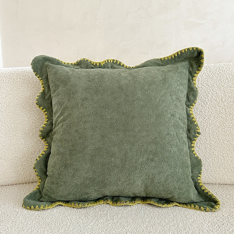 Decorative velvet cushion with wavy edge and decorative stitching