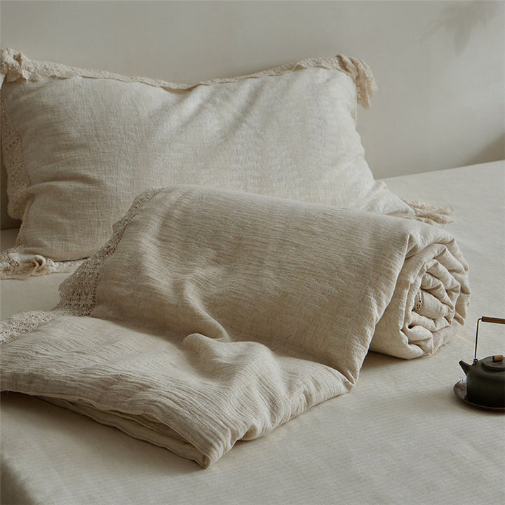Quilted bedspread and pillowcase in a washed linen look with a crochet trim
