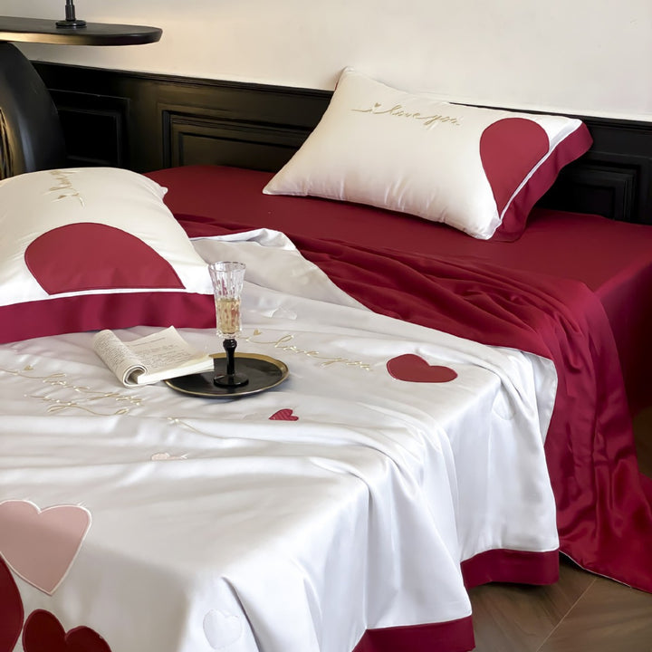 Bedding set with quilted heart appliqués and satin border
