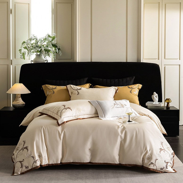 Luxurious embroidered satin bed linen set with floral corner motif and contrast piping