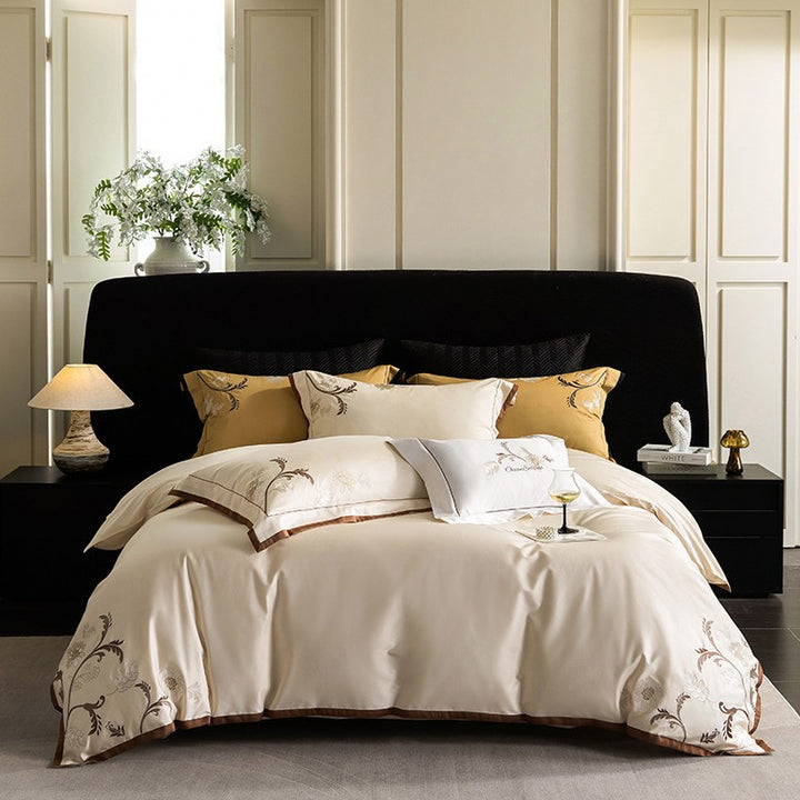 Luxurious embroidered satin bed linen set with floral corner motif and contrast piping