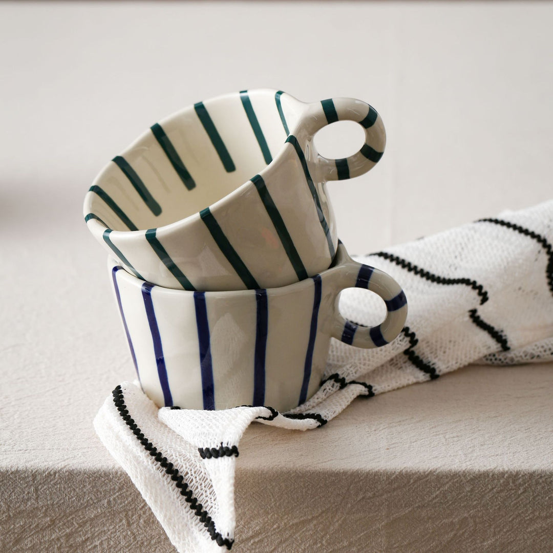 Handmade ceramic mug with ergonomic handle and wavy rim