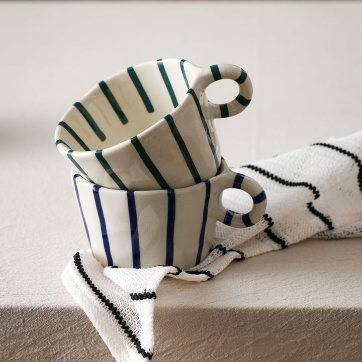Handmade ceramic mug with ergonomic handle and wavy rim