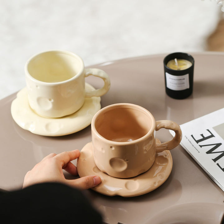 Sculptural ceramic cup set with flowing glaze and textured saucer