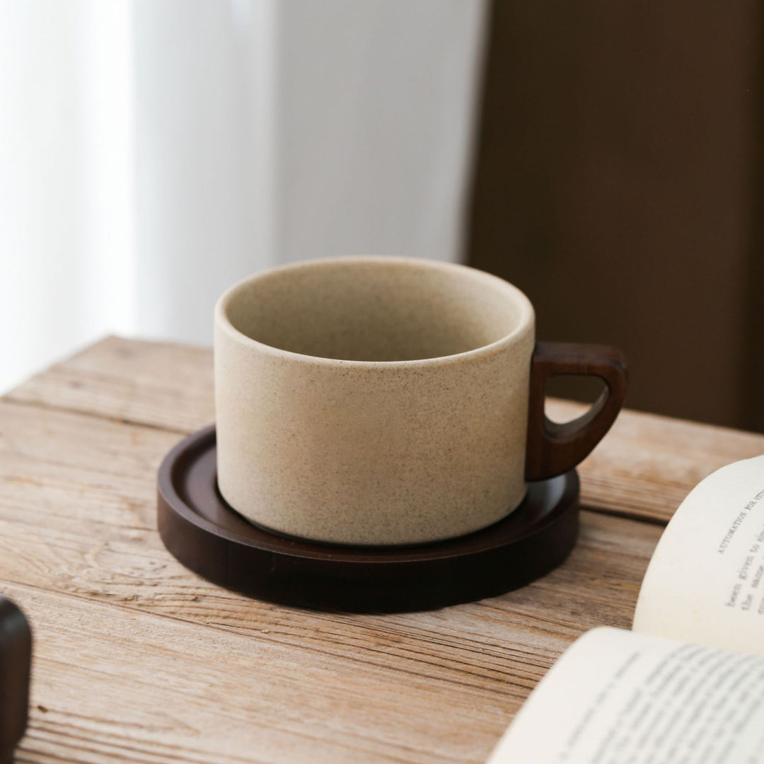 Ceramic mug with ergonomic wooden handle and matching coaster