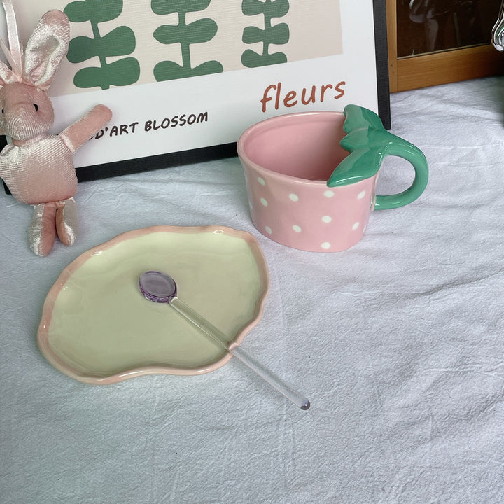 Playful ceramic mug with shaped leaf handle, saucer, and tulip spoon