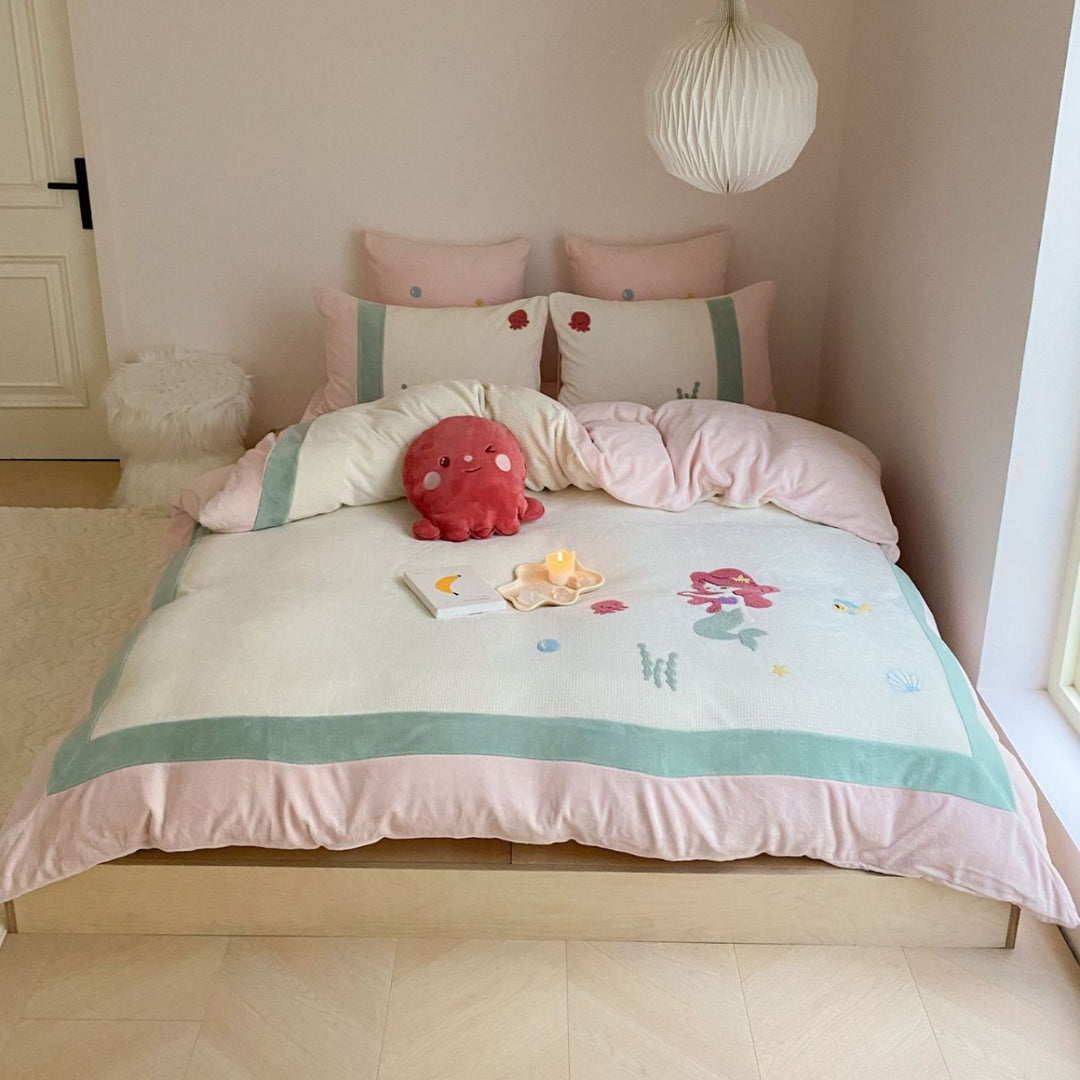 Cozy bedding set with plush border, embroidered appliqués, and reversible function
