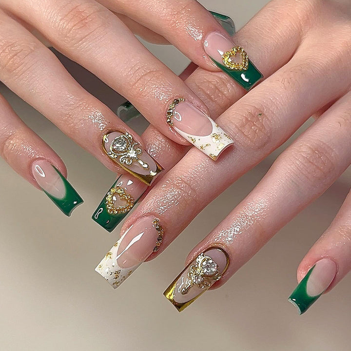Exquisite artificial nails with gold embellishments and glitter accents Kalsten