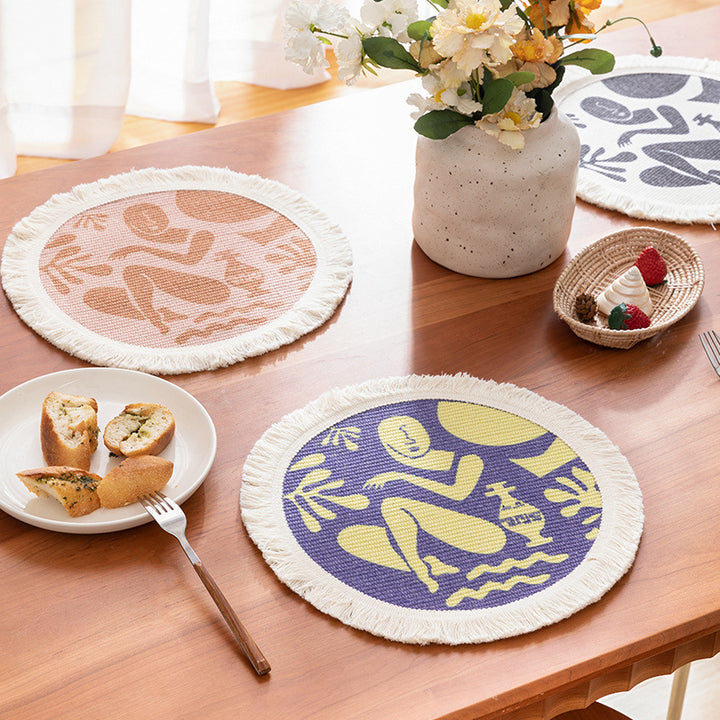 Round woven placemat with fringes and abstract figure motif Kalsten
