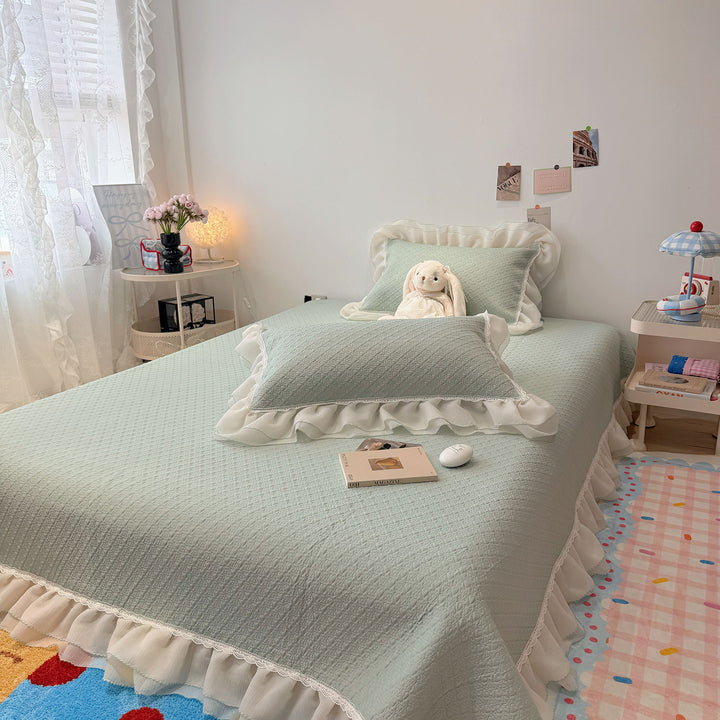 Quilted bedspread with ruffle and delicate floral quilting