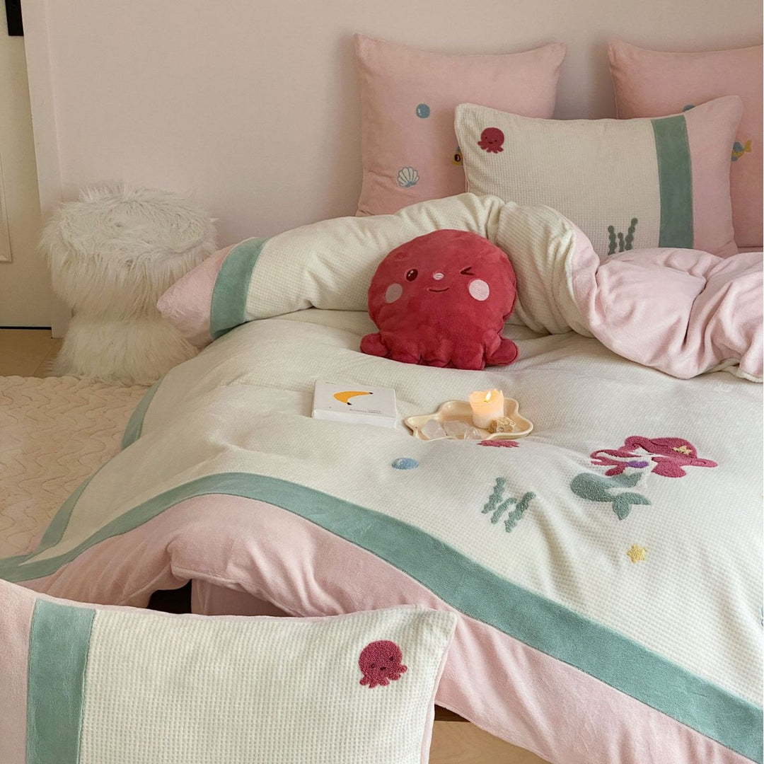 Cozy bedding set with plush border, embroidered appliqués, and reversible function