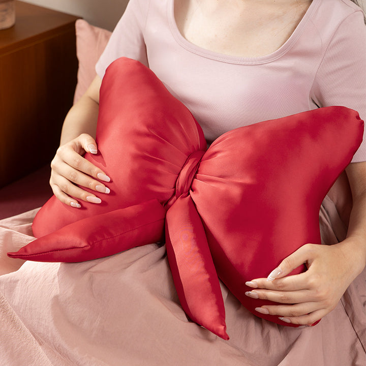 Bow-shaped decorative pillow with soft microfiber cover and decorative ribbons