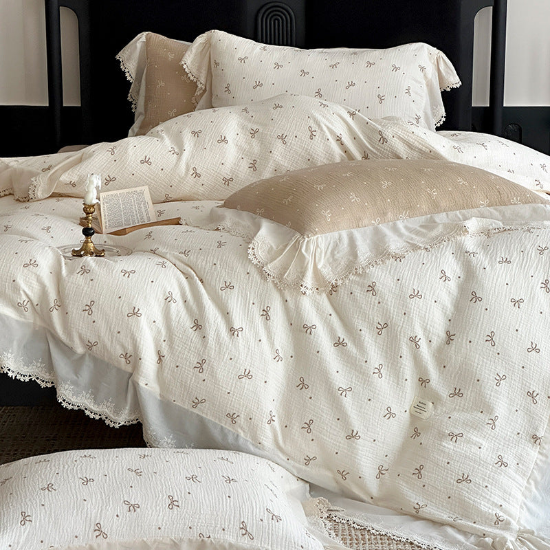Cotton muslin bedding set with ruffles, lace trim, and delicate bow print