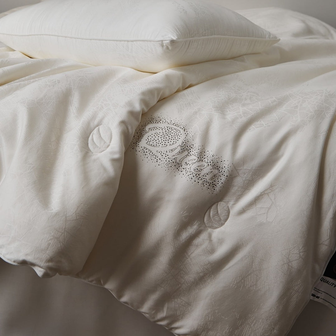 Quilted comfort duvet with fine jacquard structure and decorative button quilting