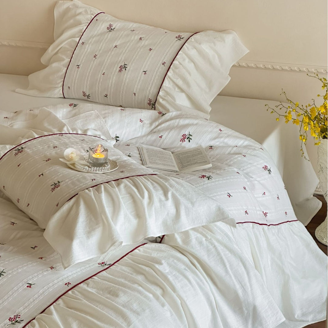 Romantic bed linen set made of cotton satin with ruffles, relief stripes, and contrasting piping