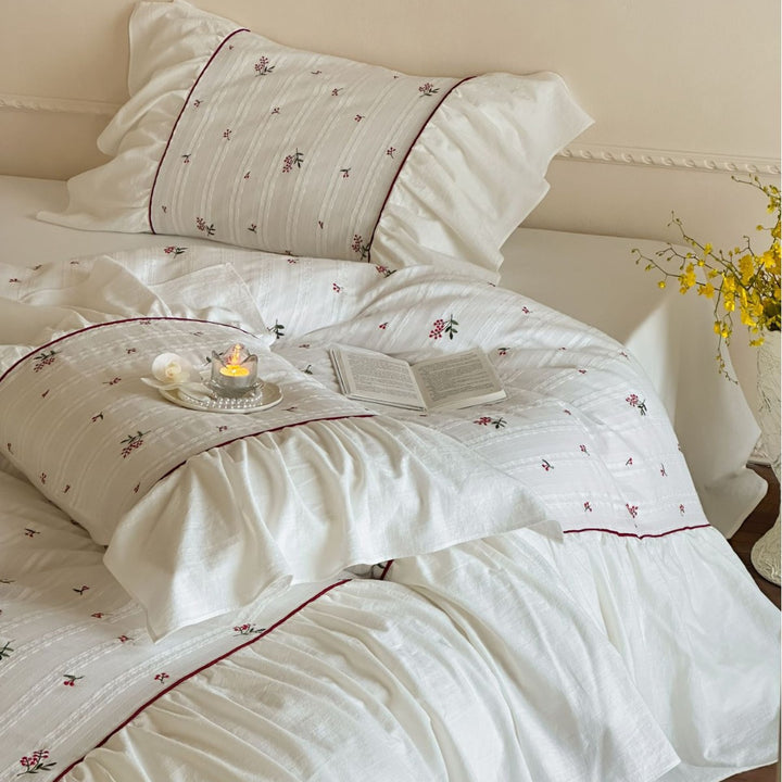 Romantic bed linen set made of cotton satin with ruffles, relief stripes, and contrasting piping