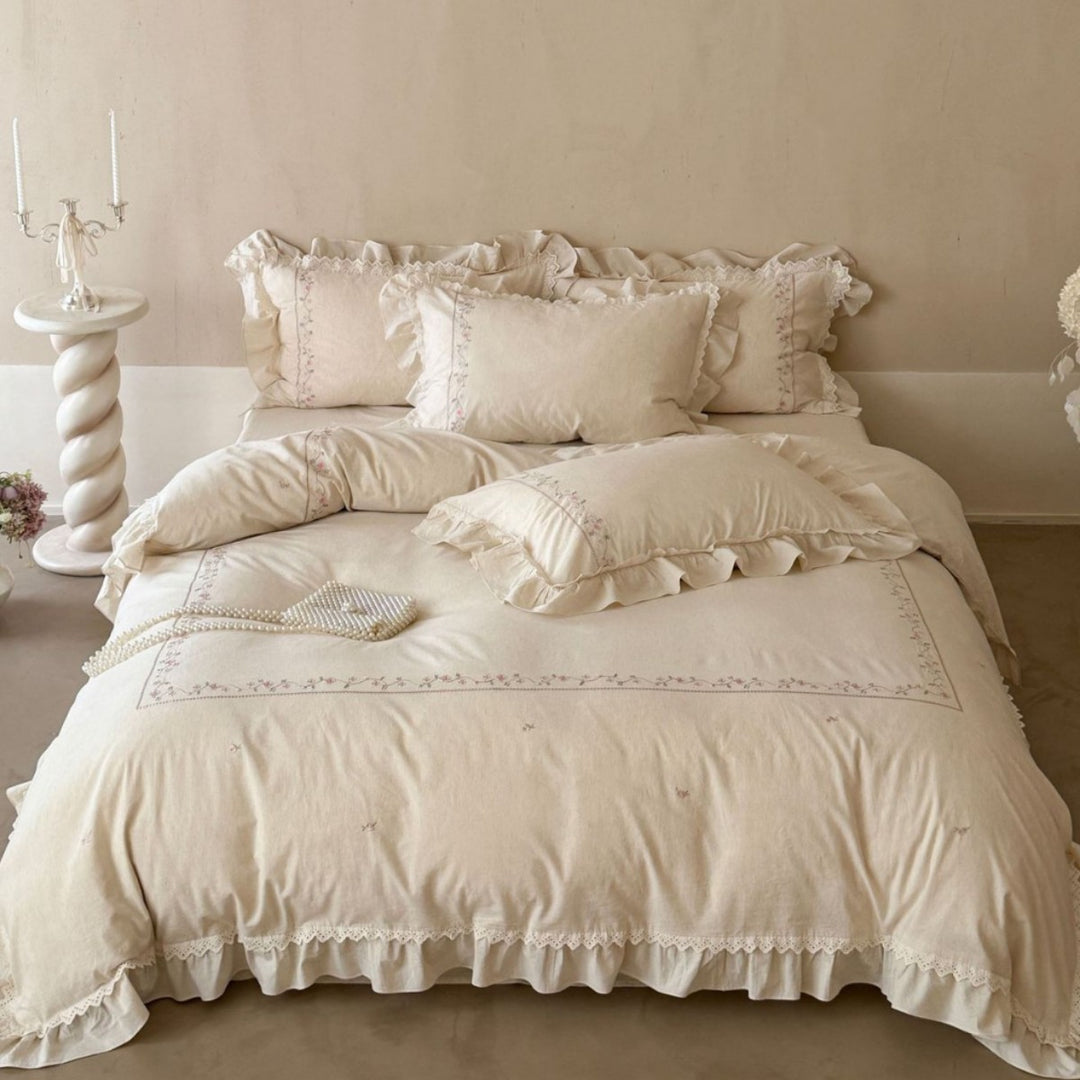 Vintage-inspired cotton bedding set with ruffles, delicate floral embroidery, and lace trim