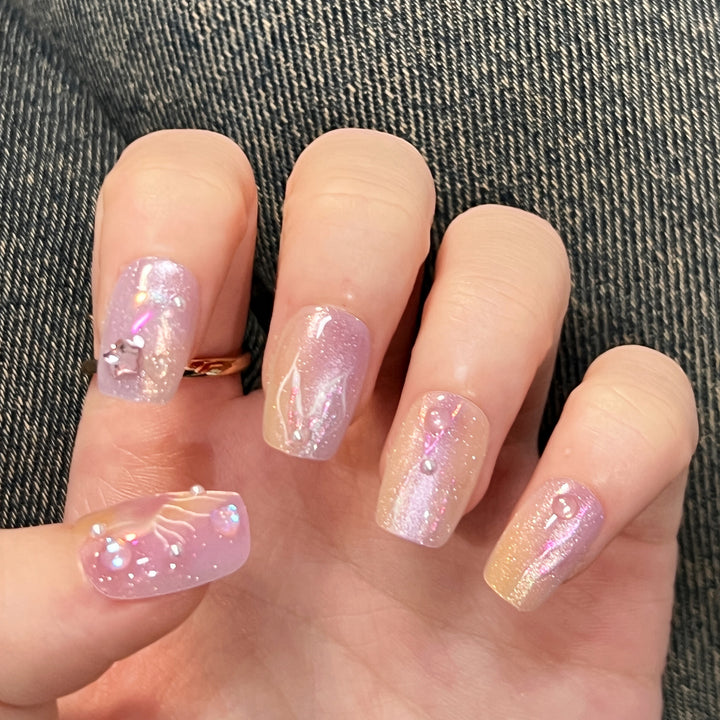 Artificial nail art with sparkling accents and transparent color gradient Kalsten