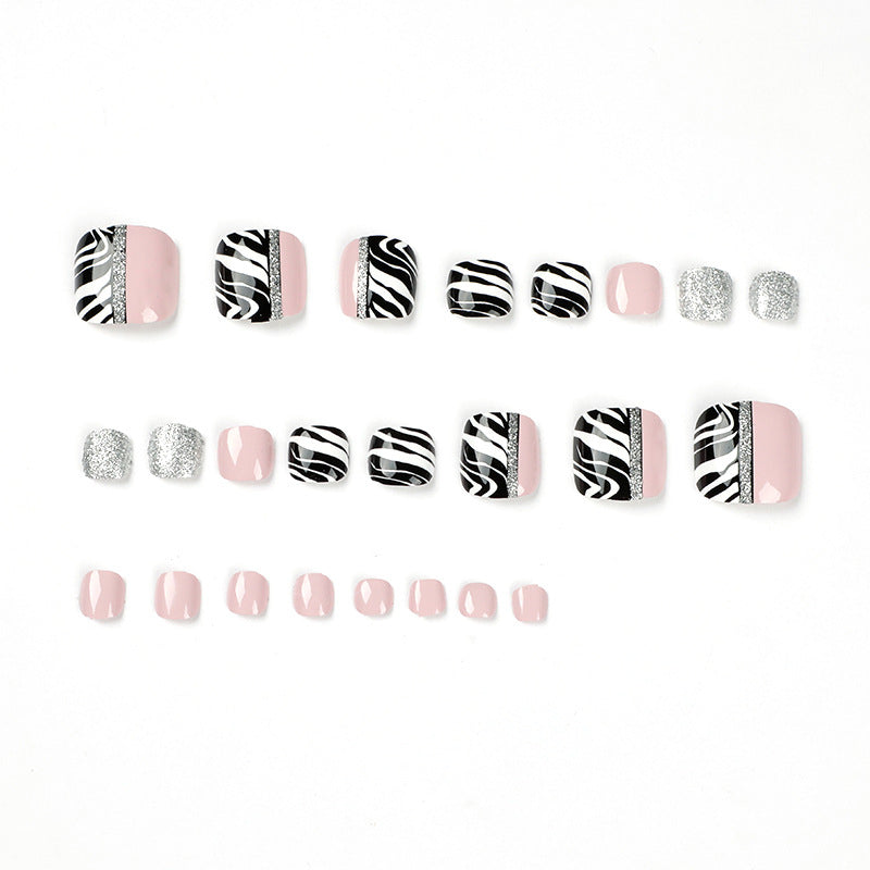 Artistic toenail art with zebra pattern and glitter accents Kalsten