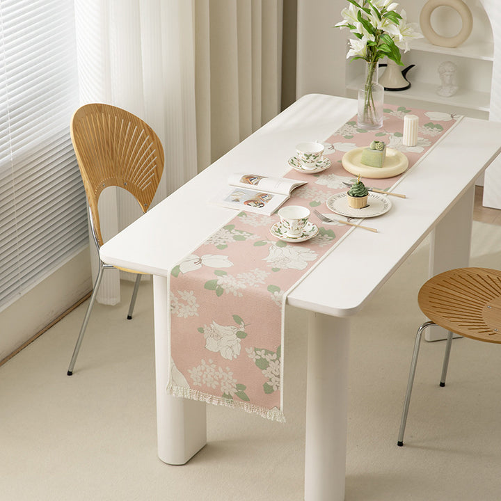 Woven botanical table runner with olive branch motif and fringed edge