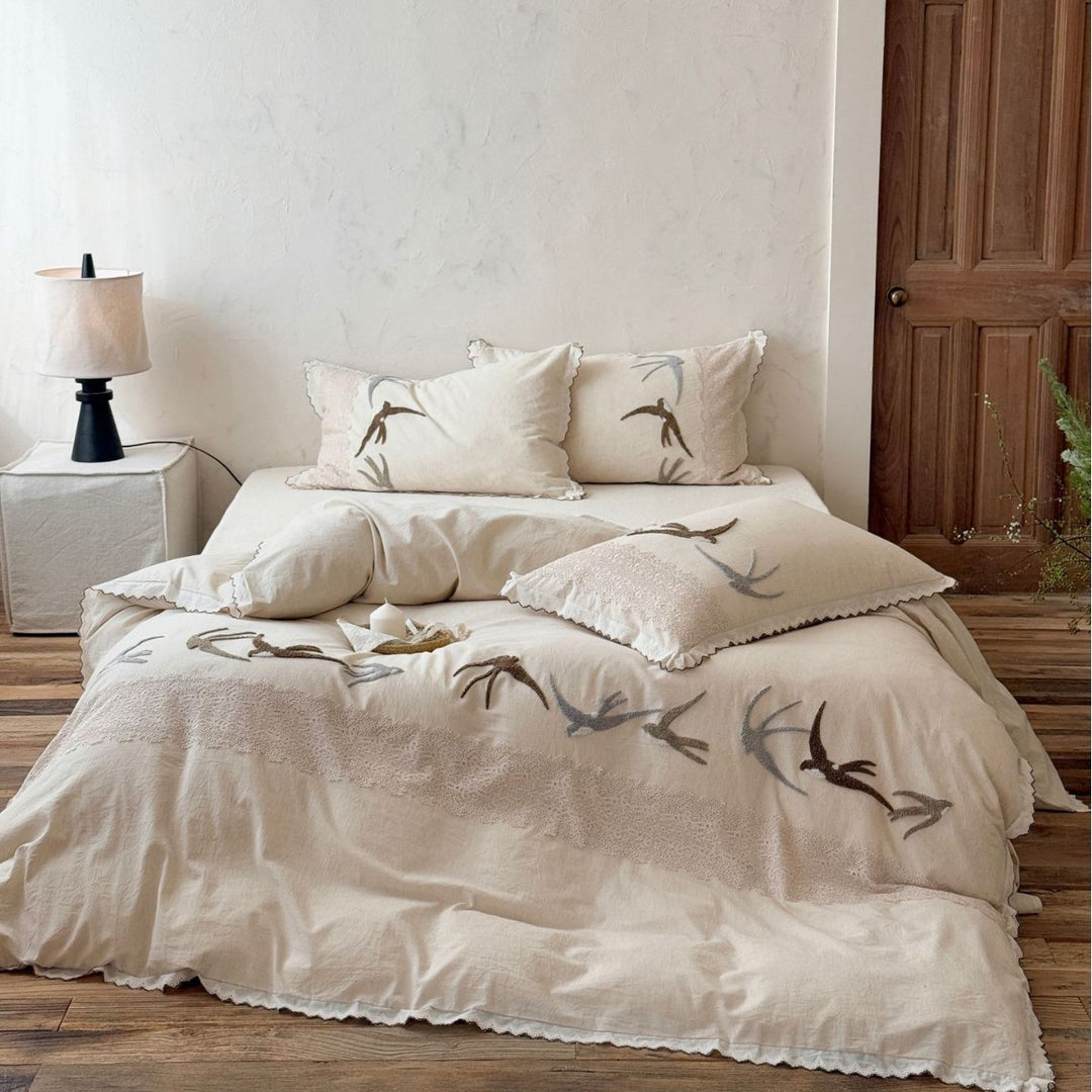 Home decor bedding set made of organic linen with hand-embroidered swallow motif and wavy hem