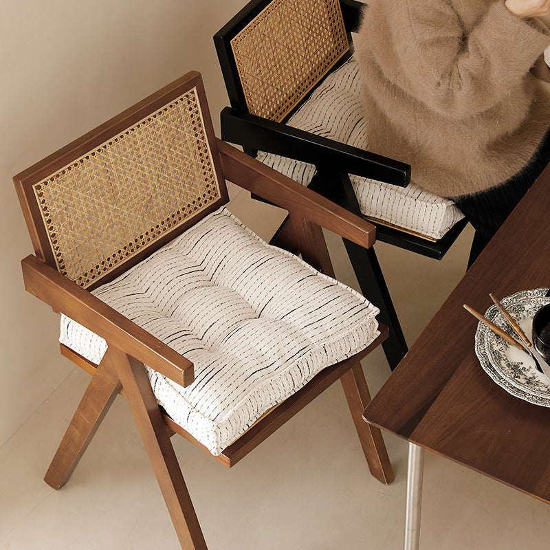 Filled floor cushion with quilted seat surface, carrying handle and fine stripe woven pattern