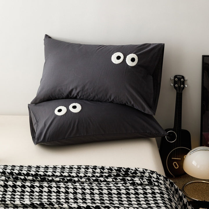 Playful cushion cover set with embroidered eye appliqués made of soft cotton fabric