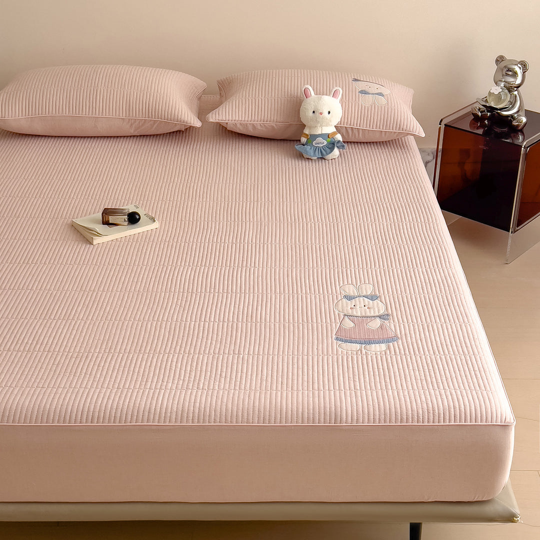 Quilted mattress topper with bunny applique and non-slip bottom