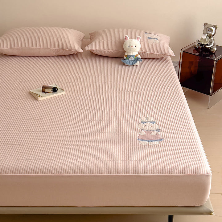 Quilted mattress topper with bunny applique and non-slip bottom