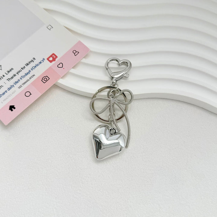 Heart-Shaped Metallic Keychain with Decorative Bow Kalsten
