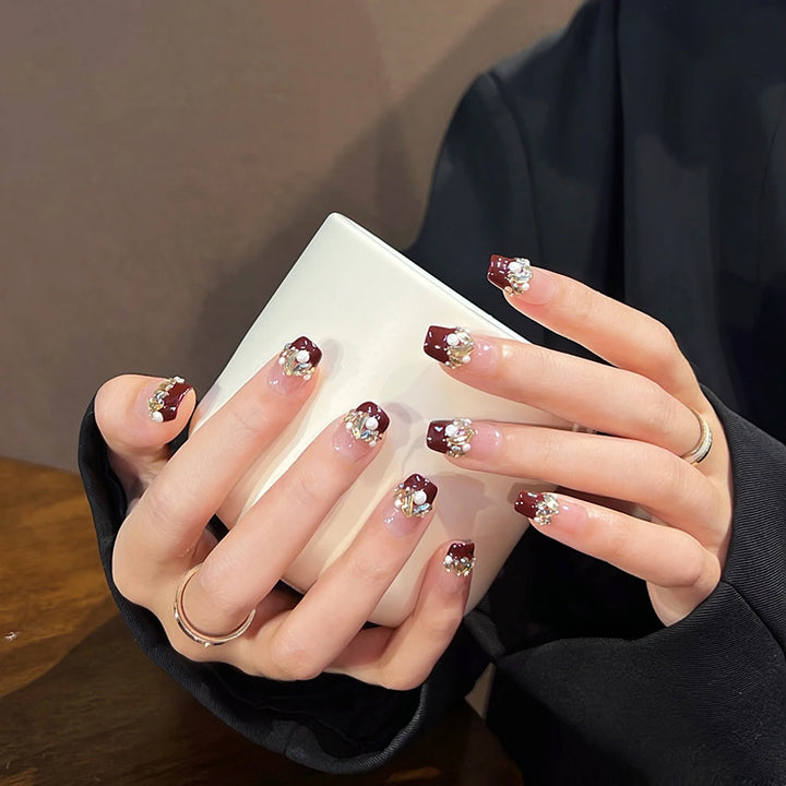 Glamorous artificial nails with decorative pearl and glitter embellishments Kalsten