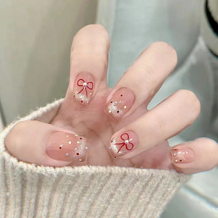 Artificial nail art with elegant bows and glitter accents Kalsten
