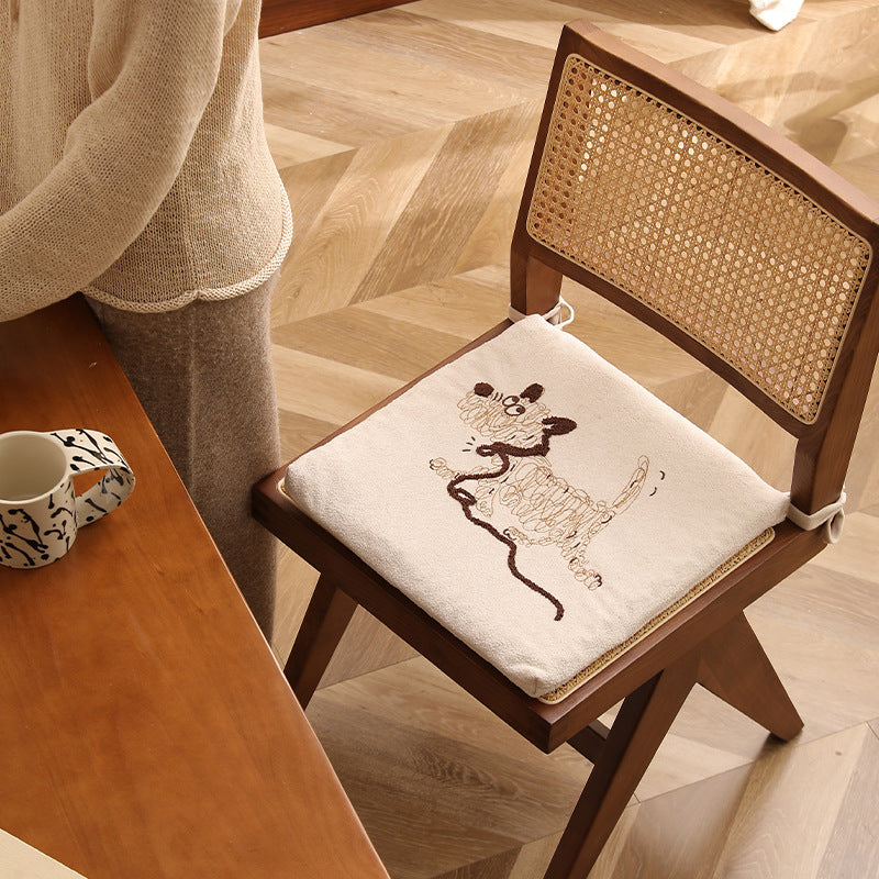 Square seat cushion with ties and embroidered dog motif