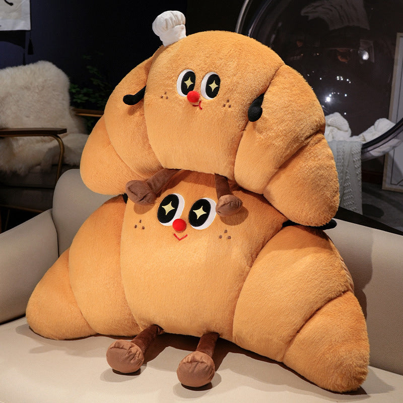 Large cuddly plush pillow in croissant shape with cute cartoon face