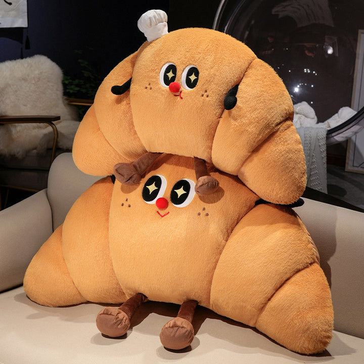 Large cuddly plush pillow in croissant shape with cute cartoon face