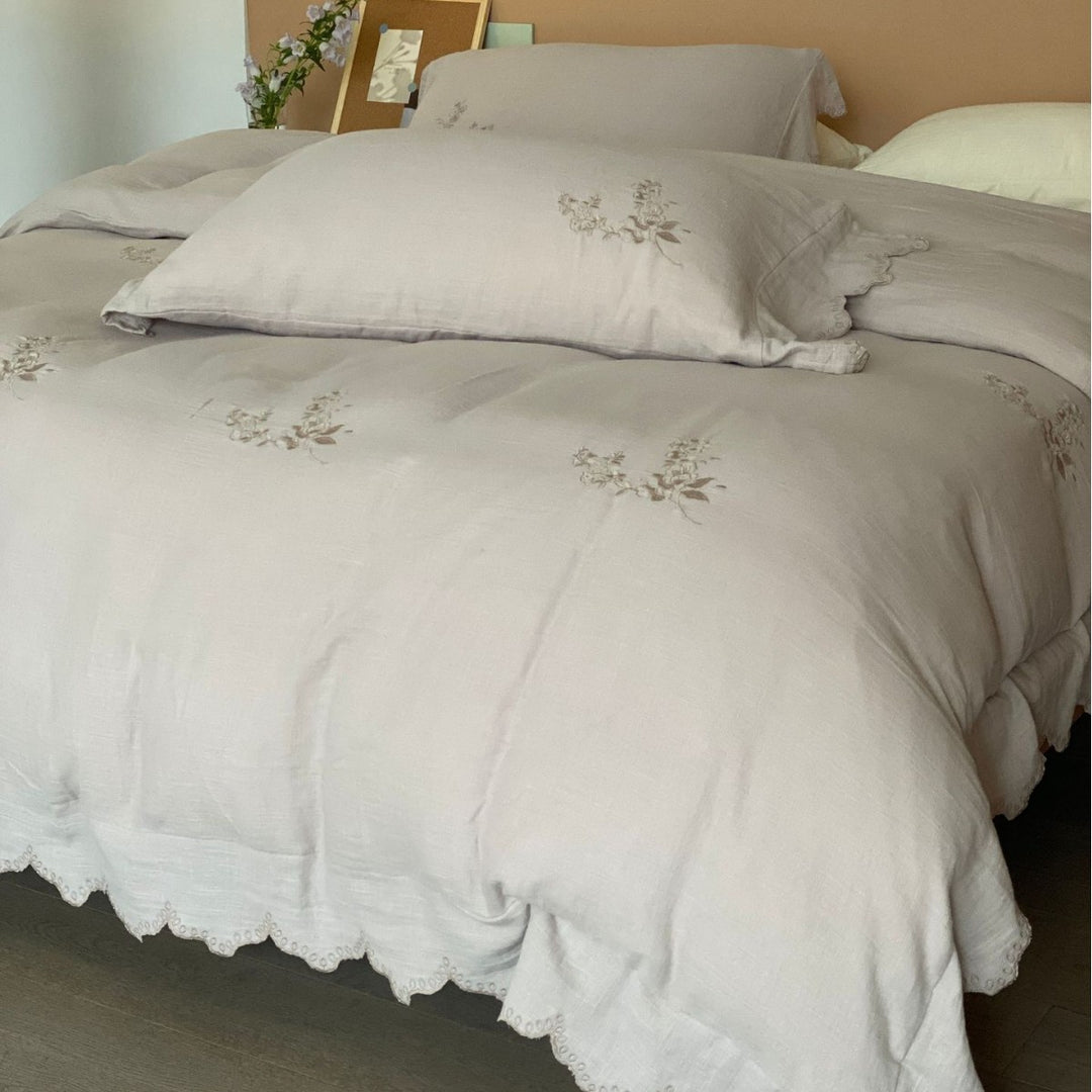 Linen look bedding set with floral embroidery and wavy hem